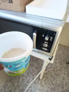 Campione di terreno in un contenitore plastico pronto per l'essiccazione in microonde in laboratorio da campo.